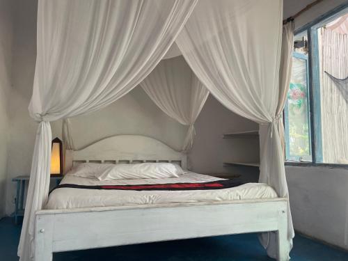 a bed with white curtains in a bedroom at Blu oceano B&B, Italian restaurant in Nembrala