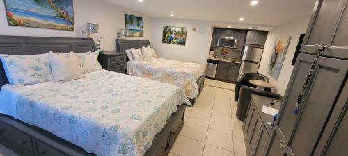 a small bedroom with two beds and a kitchen at Little Harbor Resort #114 Tampa Bay FL Beach, Bayside & 2 Pools in Ruskin