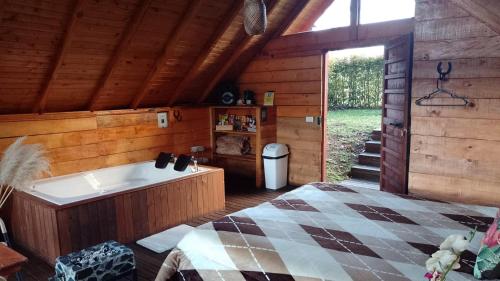 a bathroom with a tub and a bed in a cabin at Sukha Glamping in Rionegro