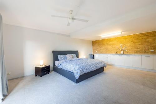 a bedroom with a bed and a brick wall at 124 Rocky Point Rd - pet friendly, air con, Wi-Fi, high chair and Cot in Fingal Bay