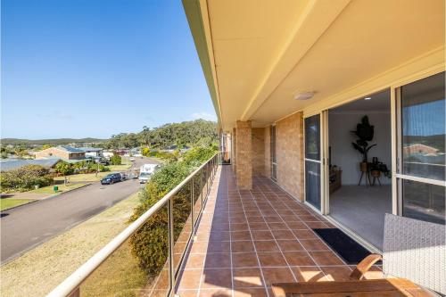 a balcony of a house with a view of a street at 124 Rocky Point Rd - pet friendly, air con, Wi-Fi, high chair and Cot in Fingal Bay