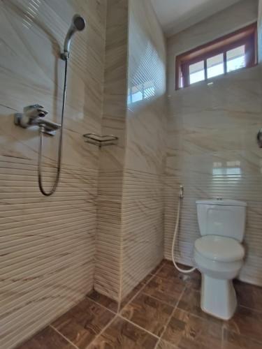 a bathroom with a toilet and a shower at villa romi in Puncak