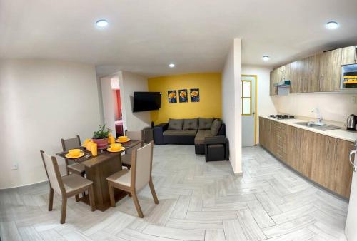 eine Küche und ein Wohnzimmer mit einem Tisch und einem Sofa in der Unterkunft Nuevo y Hermoso Departamento Pachuca in Mineral de la Reforma