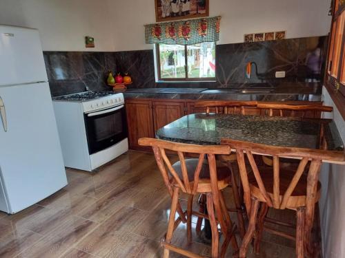 a kitchen with a table and chairs and a refrigerator at Hosteria SR in Pedernales