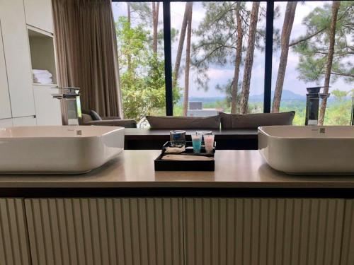 a bathroom with two sinks and a large window at Tam Dao Retreat Venuestay in Tam Ðảo