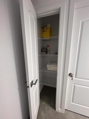 an open door to a closet with towels on shelves at Well furnished Basement Suite-With Private Entrance in Winnipeg