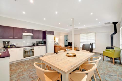 a kitchen and dining room with a wooden table and chairs at Emma's Cottage Vineyard in Lovedale