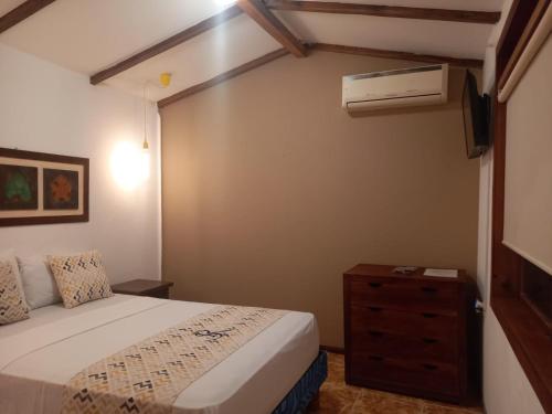 een slaapkamer met een bed met een dressoir en airconditioning bij Hosteria SR in Pedernales