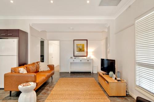 a living room with a couch and a tv at Emma's Cottage Vineyard in Lovedale