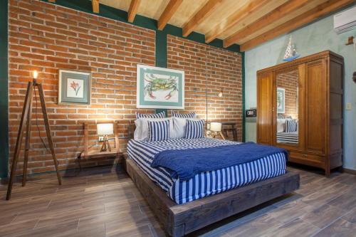a bedroom with a bed and a brick wall at Aquamarina in La Paz