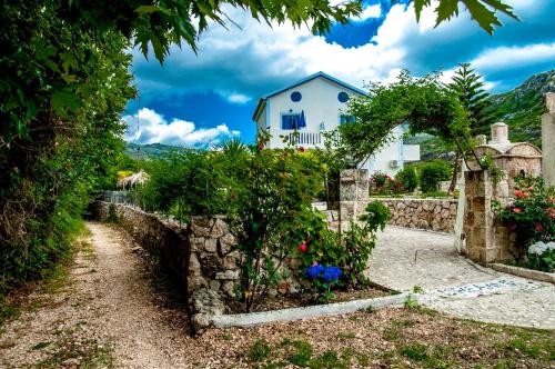 a house with a stone wall and a garden at Dreams Apartments - Katelios,Santa Barbara beach in Katelios