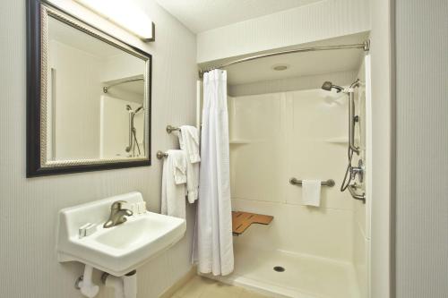 uma casa de banho branca com um lavatório e um chuveiro em Courtyard by Marriott Gulfport Beachfront em Gulfport