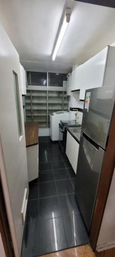 a kitchen with white cabinets and a black tile floor at Depto viña centro in Viña del Mar