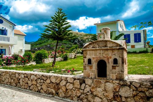 a stone wall in front of a house at Dreams Apartments - Katelios,Santa Barbara beach in Katelios