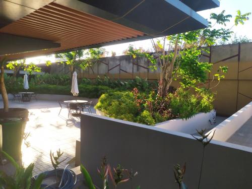 a patio with a table and chairs and plants at DeAr Caspian Apartment in Surabaya