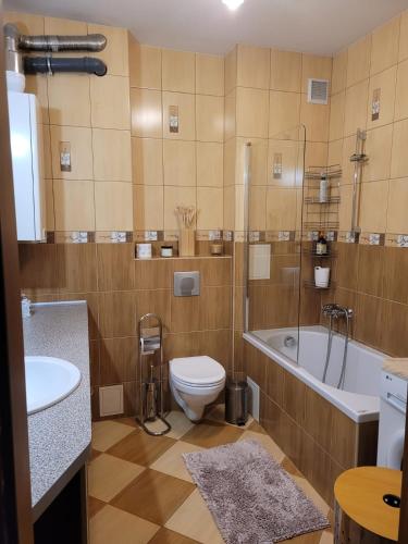 a bathroom with a toilet and a tub and a sink at Apartament w centrum Kętrzyn Mazury in Kętrzyn