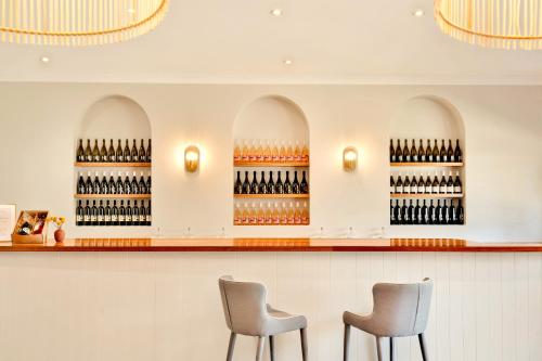 two chairs in a wine shop with wine bottles at Emma's Cottage Vineyard in Lovedale