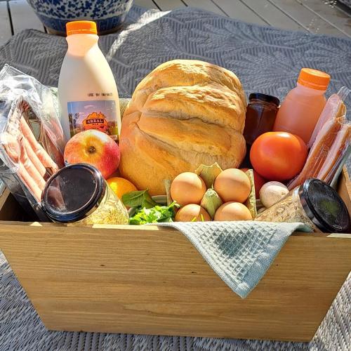 a wooden box of food with a loaf of bread and eggs at Moogie Glamp in Moogerah
