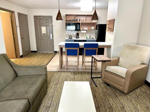 a living room with a couch and chairs and a kitchen at Candlewood Suites Savannah Airport by IHG in Savannah