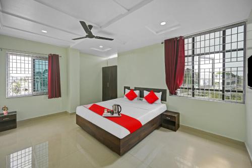 1 dormitorio con 1 cama grande con almohadas rojas en OYO VRK Residency, en Kurmannapalem
