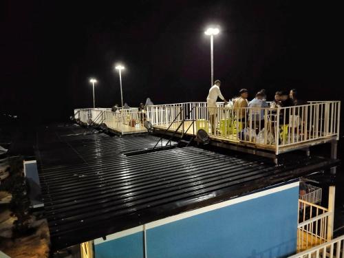 a group of people standing on a bridge at night at สเตชั่นภูทับเบิก-บ้านดาดฟ้าทะเลหมอก in Ban Tha Kok Hai