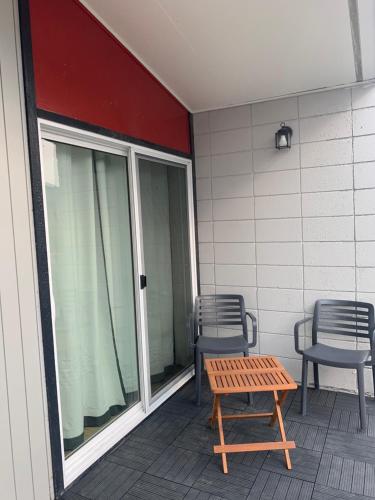 a patio with two chairs and a table on a porch at Destination Inn Cache Creek in Cache Creek