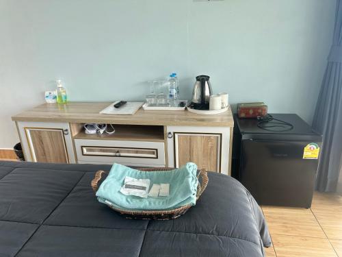 a room with a table and a basket on a bed at สเตชั่นภูทับเบิก-บ้านดาดฟ้าทะเลหมอก in Ban Tha Kok Hai