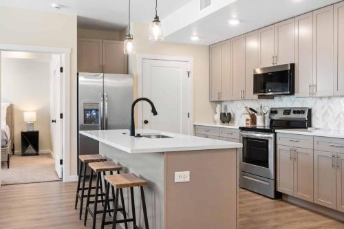 een keuken met een wastafel en een aanrecht met krukken bij Lagoon Breeze condo in St. George