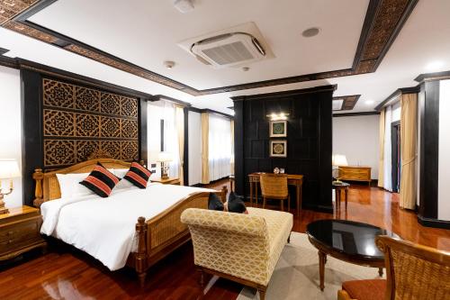 1 dormitorio con 1 cama, 1 silla y 1 mesa en Lanna Resort Chiang Mai, en Ban Dong