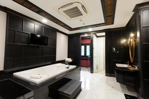 Baño negro con bañera y lavamanos en Lanna Resort Chiang Mai, en Ban Dong