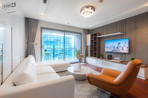 a living room with a white couch and a tv at VINCOM Center Đồng Khởi District 1 in Ho Chi Minh City