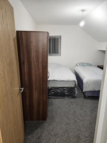 een slaapkamer met 2 bedden en een houten deur bij One bedroom apartment in Birmingham