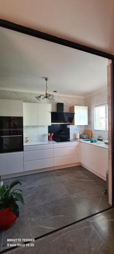 une grande cuisine avec des placards blancs et un plafond dans l'établissement Villa Ange Azur 2, à Villeneuve-Loubet