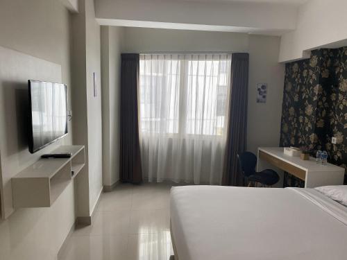 a hotel room with a bed and a window at Padina Soho And Residence in Kebonbesar