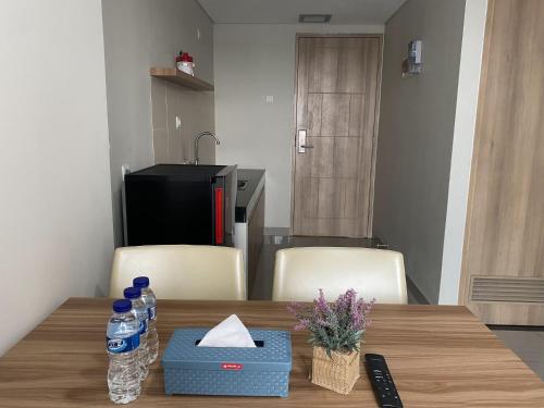 a table with two chairs and bottles of water on it at Padina Soho And Residence in Kebonbesar