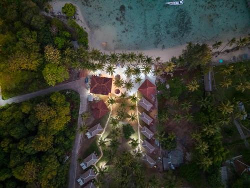 an overhead view of a resort with trees and a beach at Eco Casa in Karimunjawa