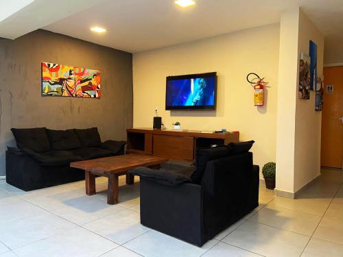 sala de estar con 2 sofás y TV en Hostel Pelo Mundo, en Río de Janeiro