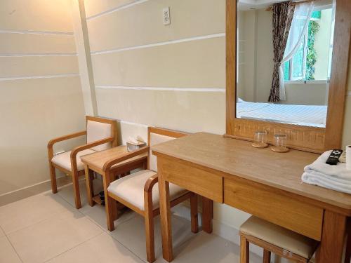 a bathroom with a wooden vanity and a mirror at Royal Hotel in Ho Chi Minh City