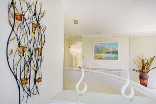 um quarto branco com uma escada com obras de arte em vidro em Beachside Manor em Sapphire Beach