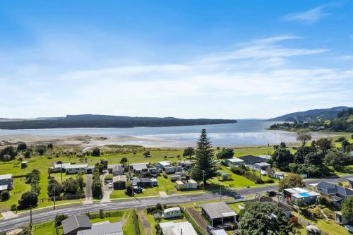 an aerial view of a village next to a body of water at Port Waikato Holiday Park in Port Waikato