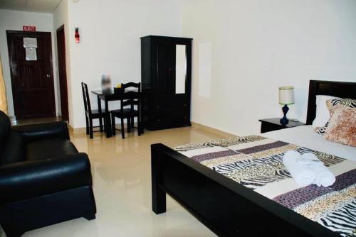 a bedroom with a bed and a chair and a table at Coastal Bay Suite & Golf Cart Rental in San Pedro