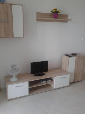 a living room with a television on a wooden entertainment center at Apartman Halex Centrum City aupark in Piešťany