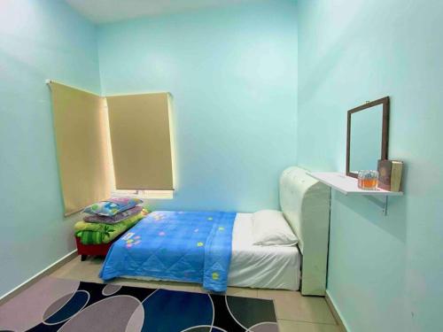Cette chambre bleue comprend un lit et un miroir. dans l'établissement Homestay Naim Sabak Bernam, à Sabak Bernam