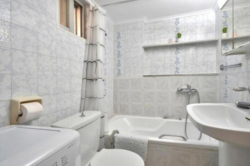 biała łazienka z toaletą i umywalką w obiekcie Sunset Studios Kavala w mieście Kawala