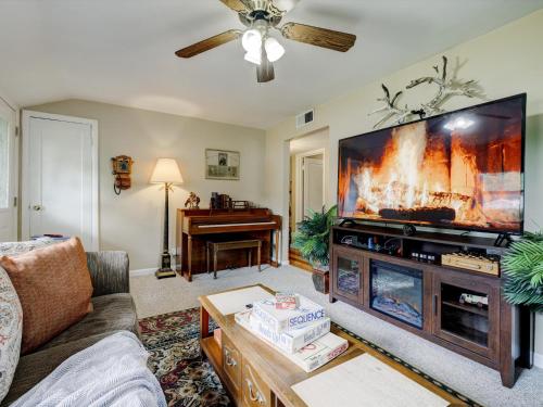 a living room with a large flat screen tv at Mid-Century Brick Bungalow Home in Evansville