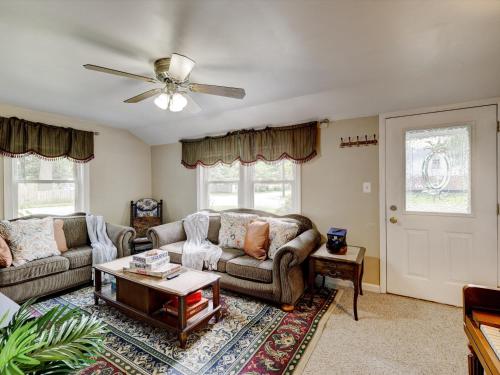 un soggiorno con 2 divani e un ventilatore a soffitto di Mid-Century Brick Bungalow Home a Evansville