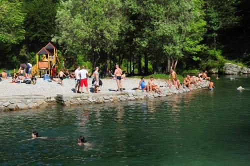 a group of people in the water at a beach at Rozica in Idrija