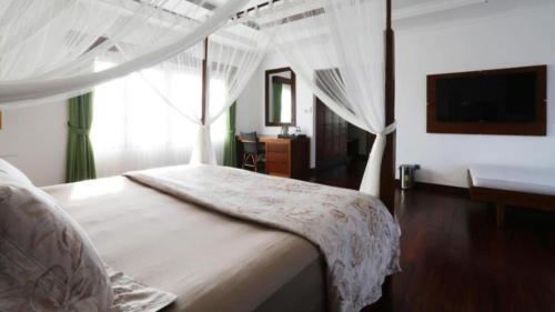 a bedroom with a bed with a white canopy at Medewi Surf Villa Luxury in Airsatang