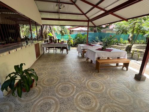 a restaurant with tables and chairs and a patio at Tortuguero Hill Rooms in Tortuguero