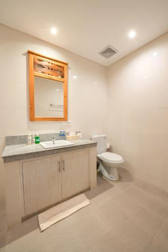 a bathroom with a sink and a toilet at Sau Bali Beach House Canggu in Canggu